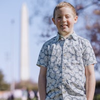 a young boy standing in front of the washington monument